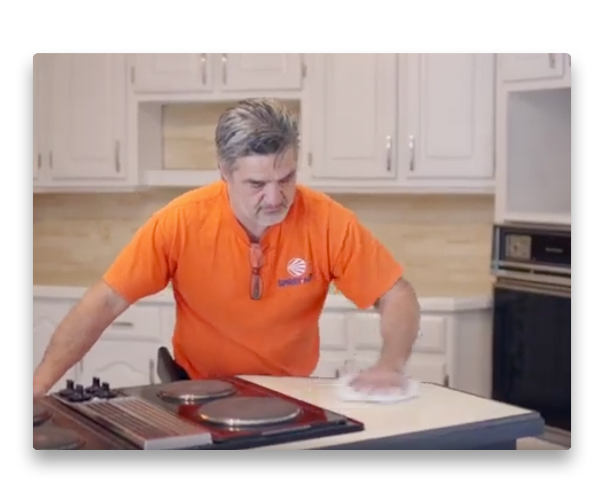 An image depicting a painter cleaning up after painting kitchen cabinets