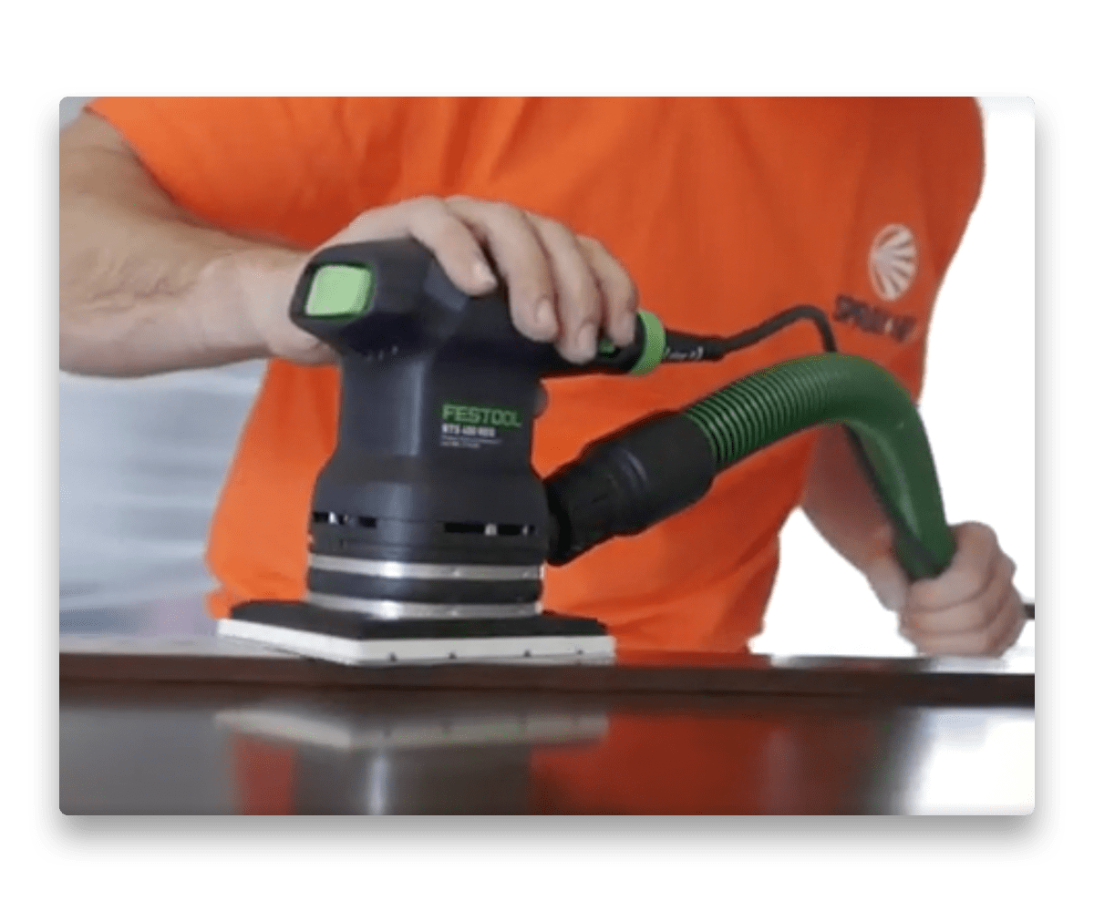 An image of sanding a kitchen cabinet in preparation for painting.